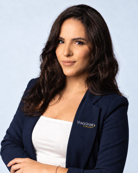 Larissa, sócia da Viaggiamo, de blazer azul-marinho com o logotipo da agência.