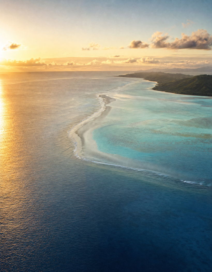 Vista aérea de uma costa tropical ao entardecer.